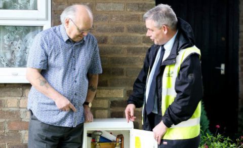 A Northern Gas Networks engineer showing an elderly man a gas meter.