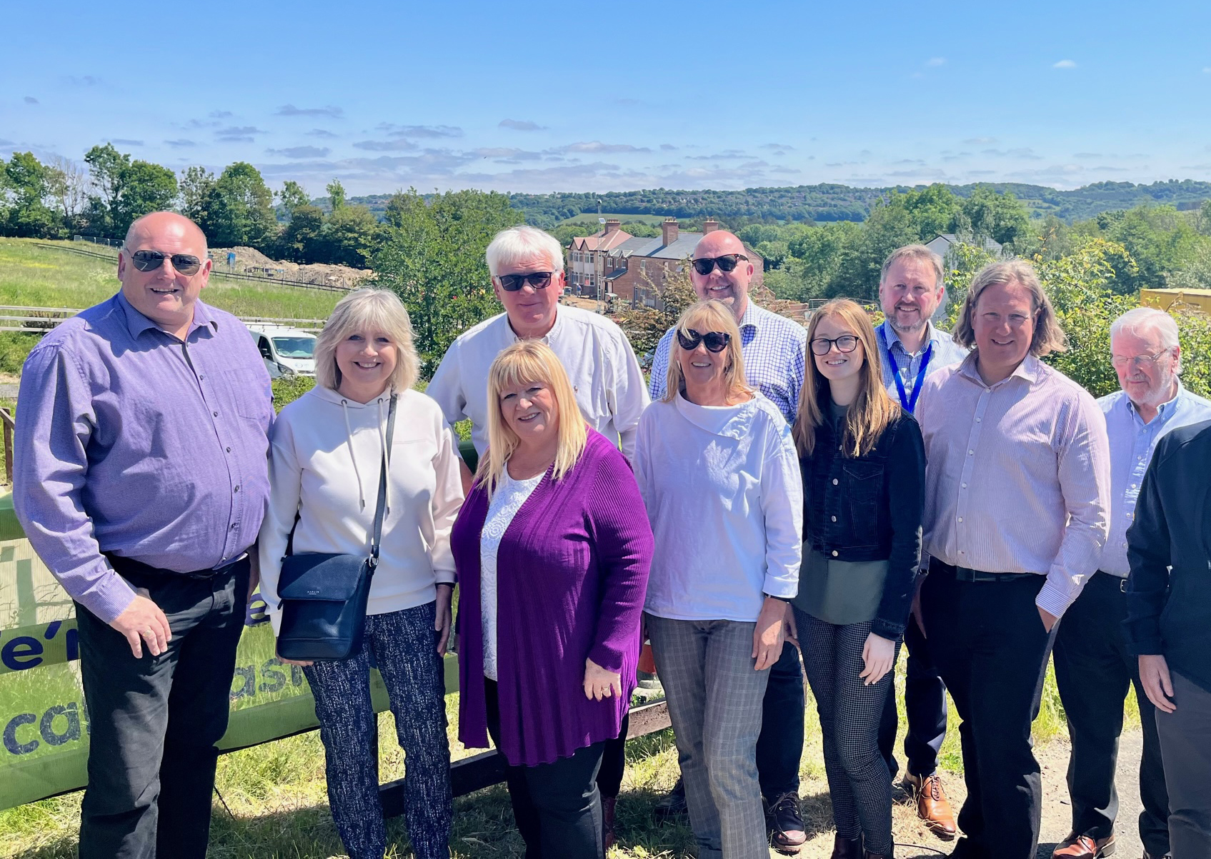 Image of Independent Stakeholder Group members, a group of 10 people, with a mix of men and women standing outside and smiling