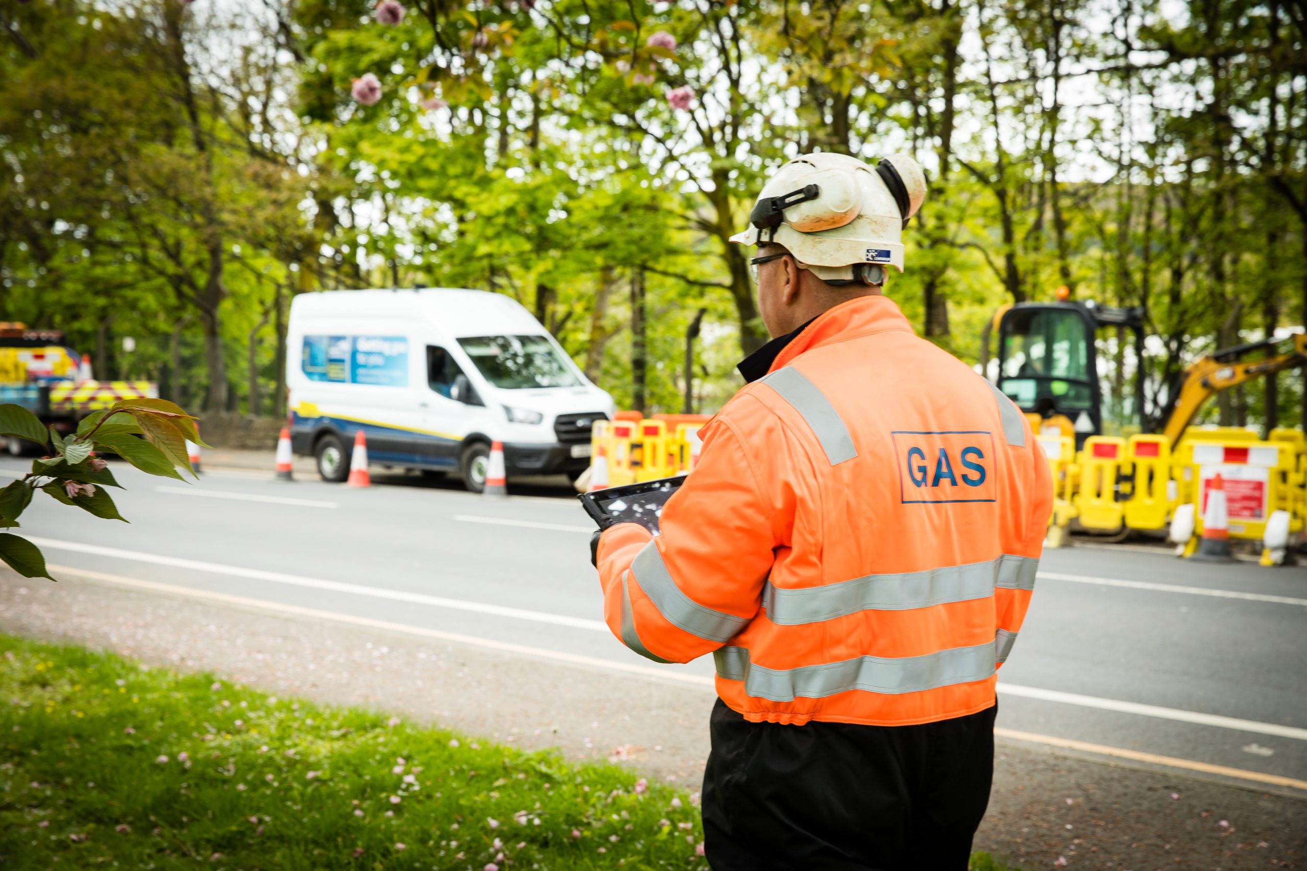 Image of Northern Gas workman stood on roadside next to Northern Gas van and digger