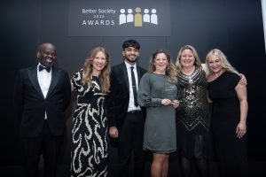 Image of team at NGN collecting award on stage.